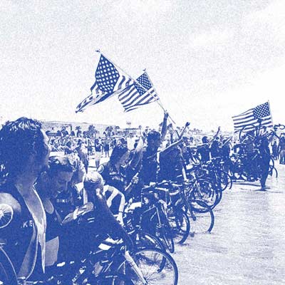 Bike and Build riders celebrating with American Flags on the Pacific Coast.